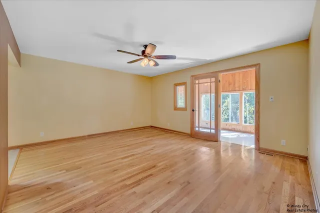 a view of an empty room with a window and wooden floor