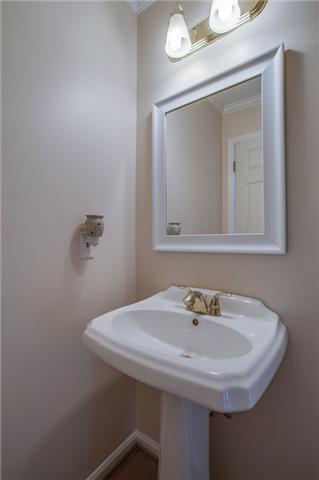 8694 Haselton Road Nashville, TN 37221 - Photo 9 of 19 Half bath with crown molding, pedestal sink and hardwood floors.