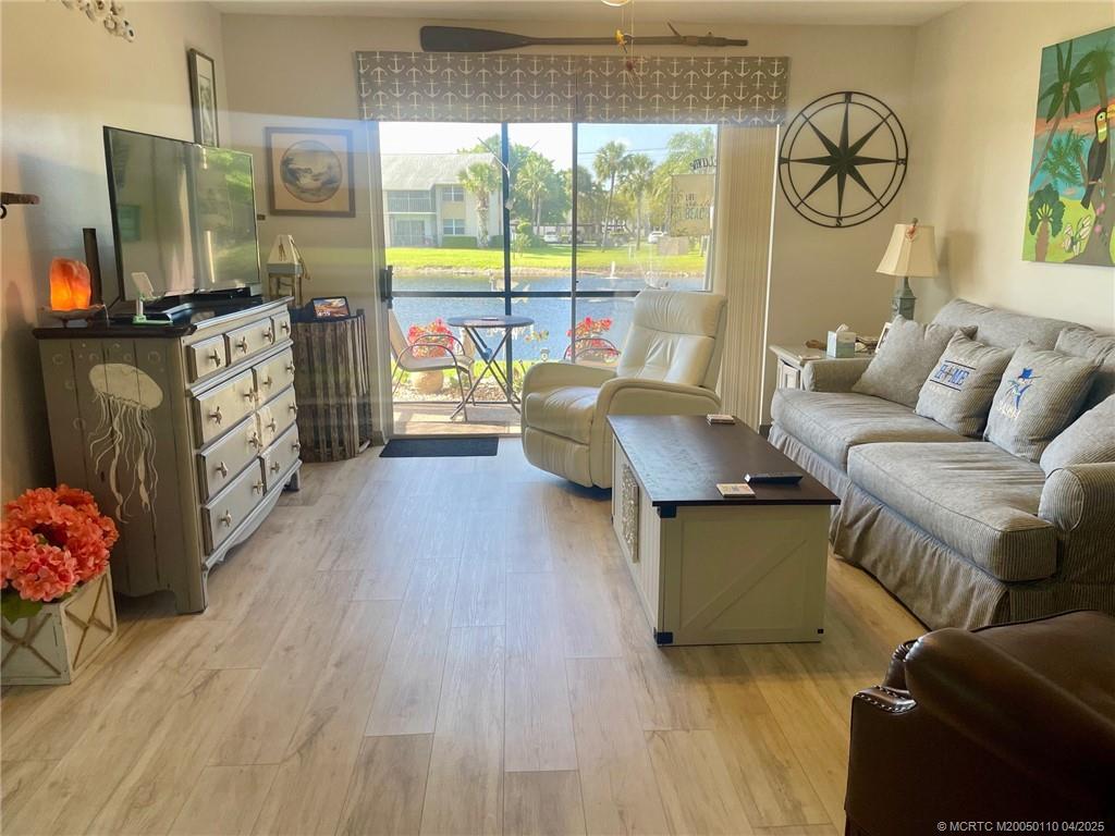 3121 Southeast Aster Lane, Unit 1601 Stuart, FL 34994 - Photo 26 of 58 a living room with furniture and a floor to ceiling window