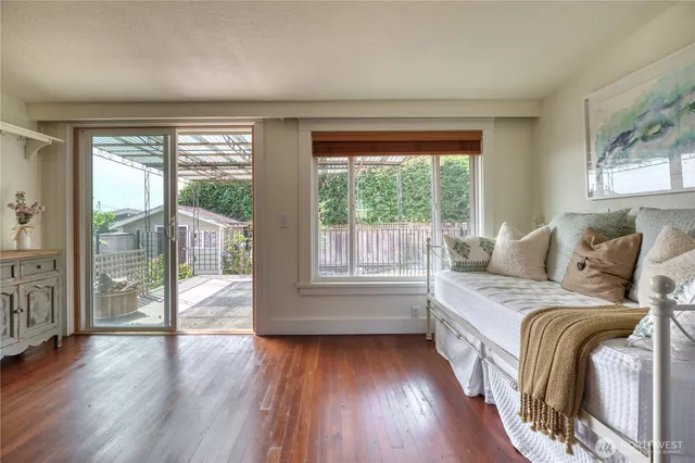 a spacious bedroom with a bed and wooden floor