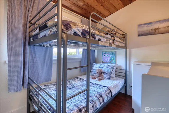 a bedroom with bed and wooden floor