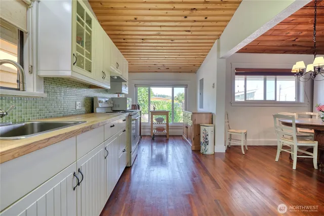 a kitchen with stainless steel appliances granite countertop wooden floors a stove and a sink