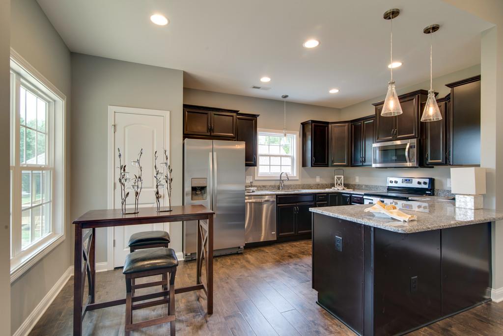 417 Kaiser Road Dickson, TN 37055 - Photo 6 of 30 a kitchen with kitchen island granite countertop a sink appliances and cabinets