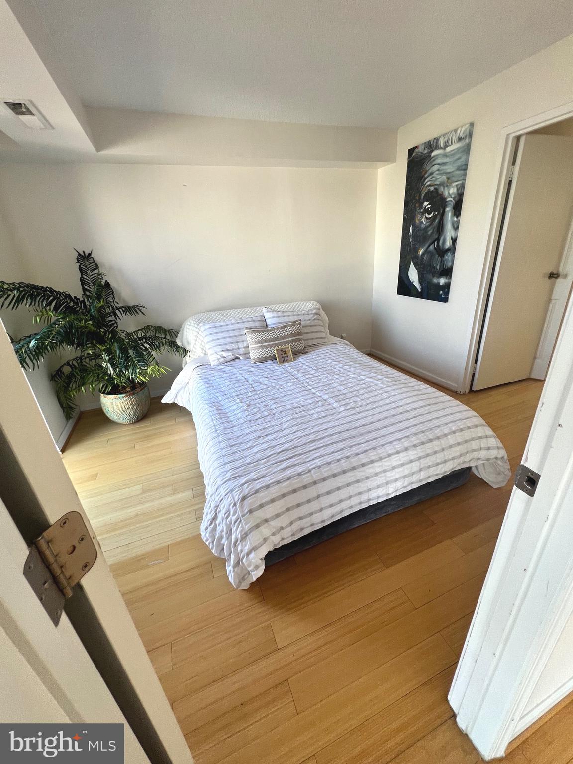 1401 North Rhodes Street, Unit 503 Arlington, VA 22209 - Photo 11 of 25 a bedroom with a bed and a painting on the wall