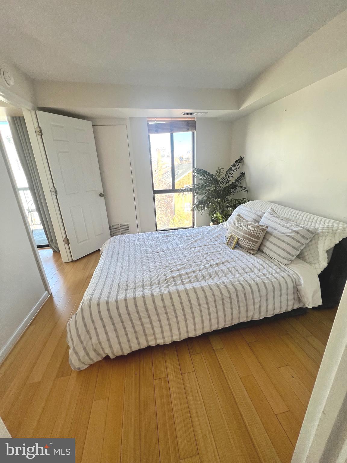 1401 North Rhodes Street, Unit 503 Arlington, VA 22209 - Photo 12 of 25 a bedroom with a bed and wooden floor