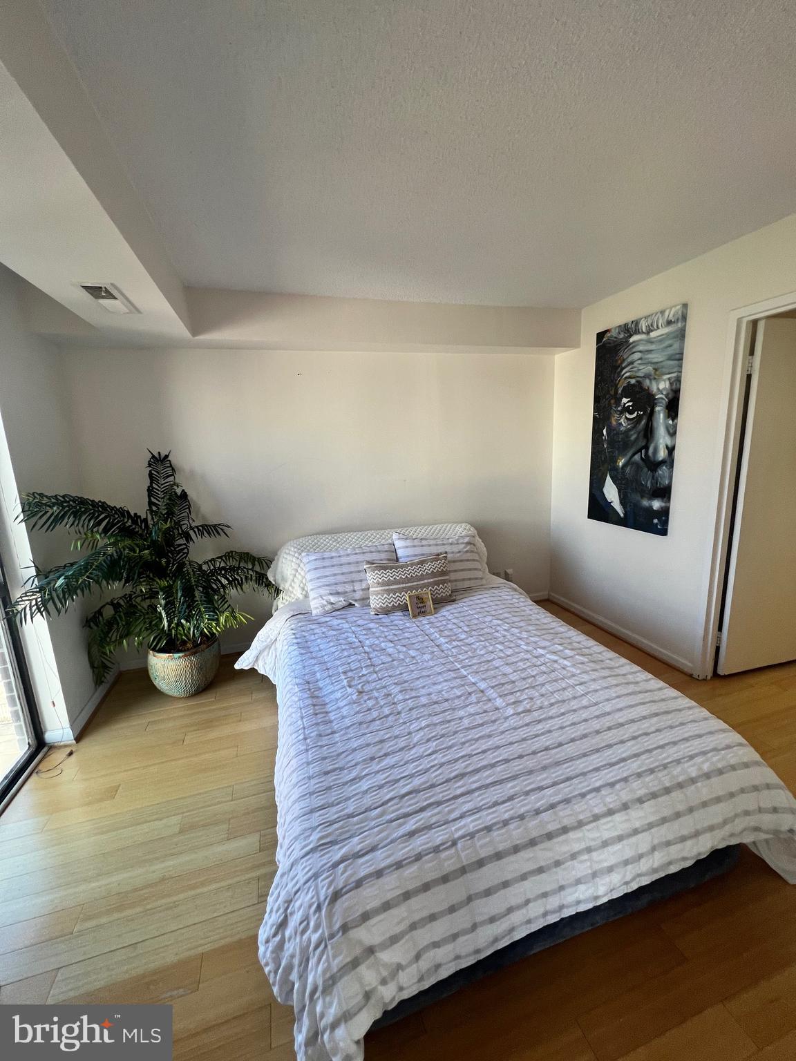 1401 North Rhodes Street, Unit 503 Arlington, VA 22209 - Photo 15 of 25 a bedroom with a bed and a dresser