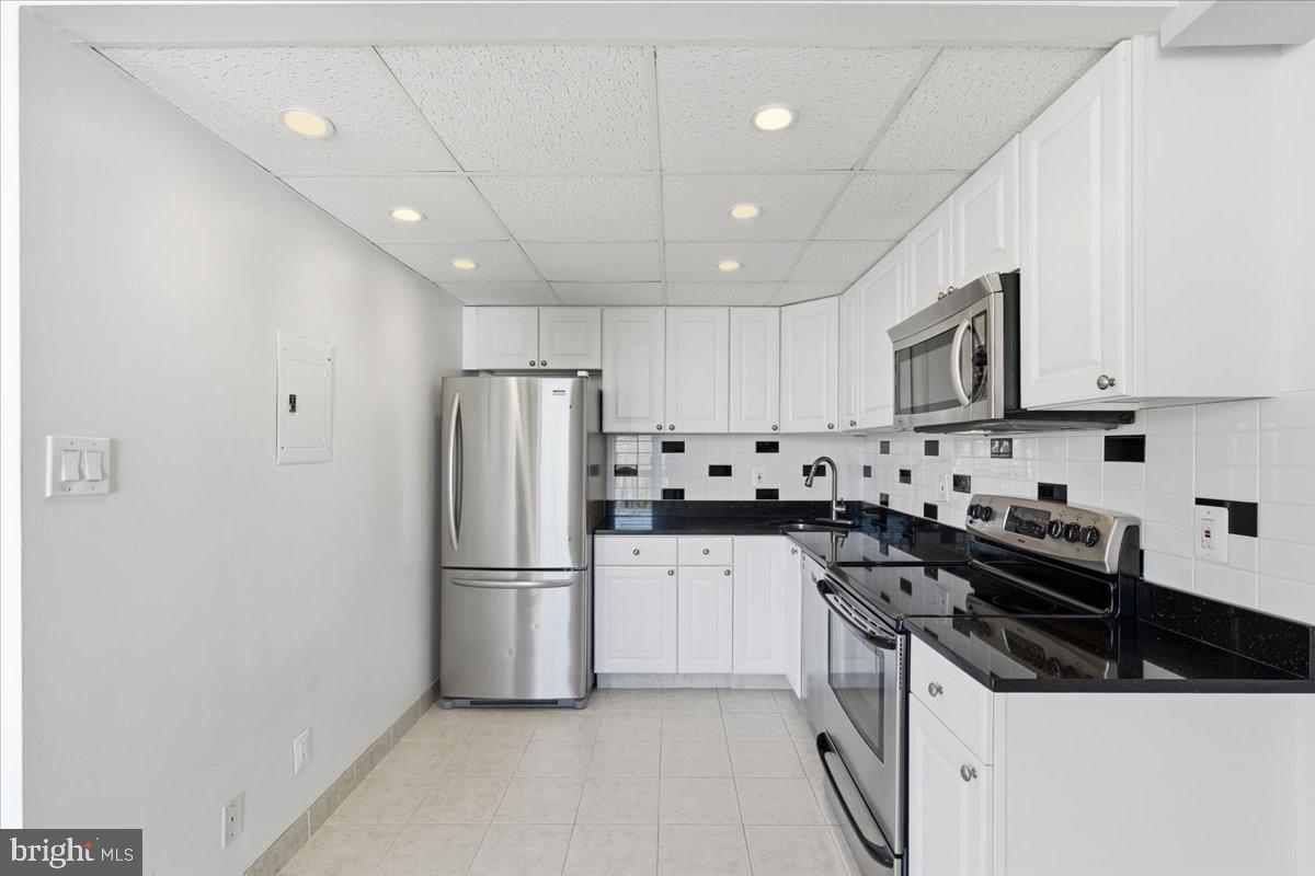 1401 North Rhodes Street, Unit 503 Arlington, VA 22209 - Photo 6 of 17 a kitchen with stainless steel appliances a refrigerator stove microwave and cabinets