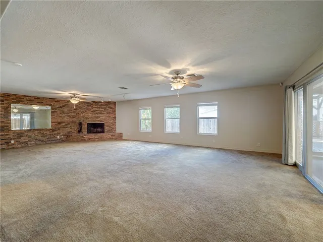 an empty room with windows and ceiling fan