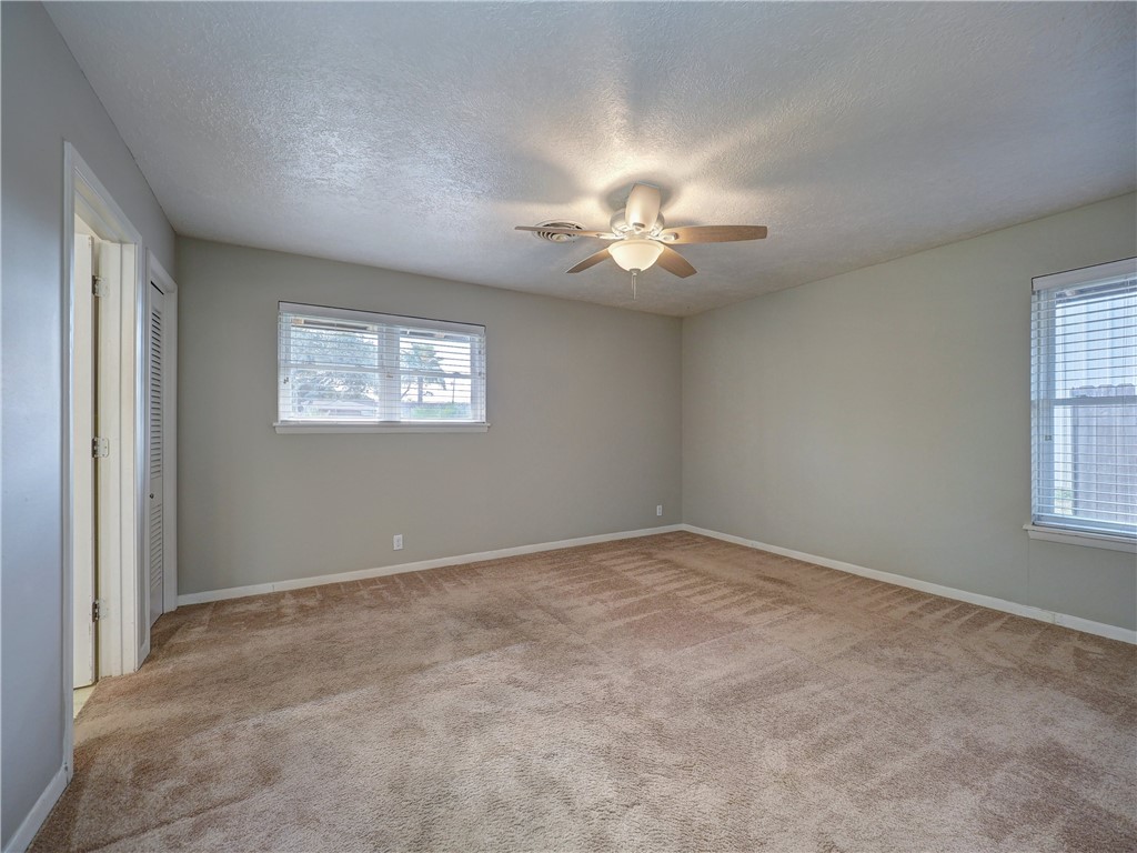 161 Sunset Ingleside, TX 78362 - Photo 17 of 35 an empty room with windows and ceiling fan