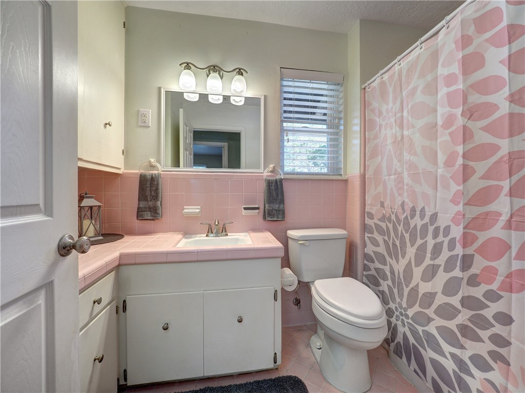 161 Sunset Ingleside, TX 78362 - Photo 19 of 35 a bathroom with a sink a toilet a mirror and shower curtain