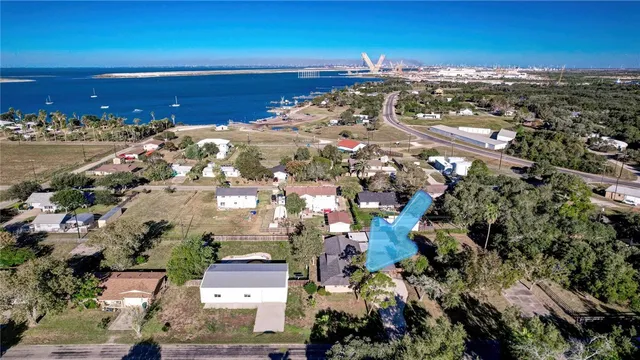 an aerial view of ocean and residential houses with outdoor space