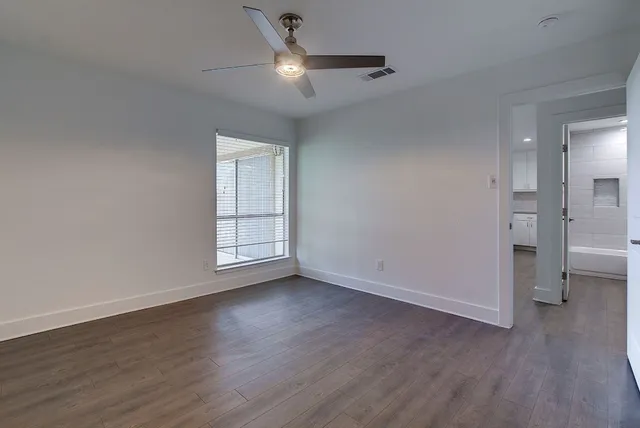 a view of an empty room with wooden floor