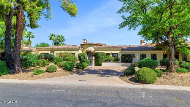 front view of a house with a yard and potted plants