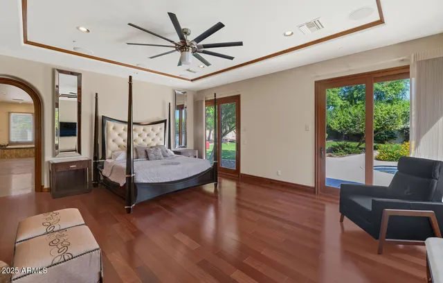 a living room with furniture a ceiling fan and a large window