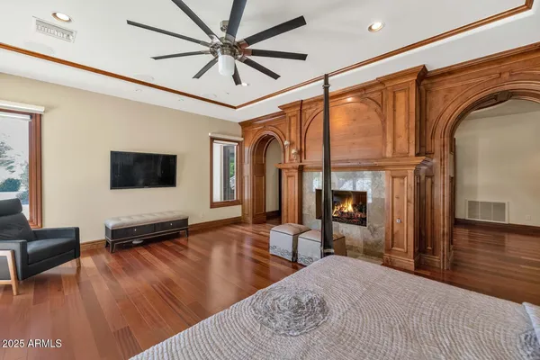 a spacious bedroom with a bed and a flat screen tv