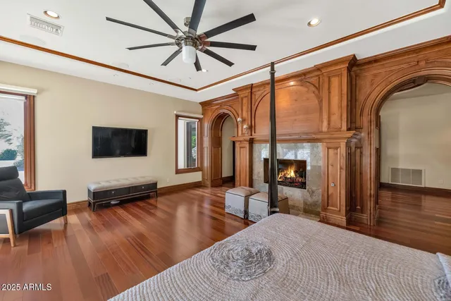 a spacious bedroom with a bed and a flat screen tv