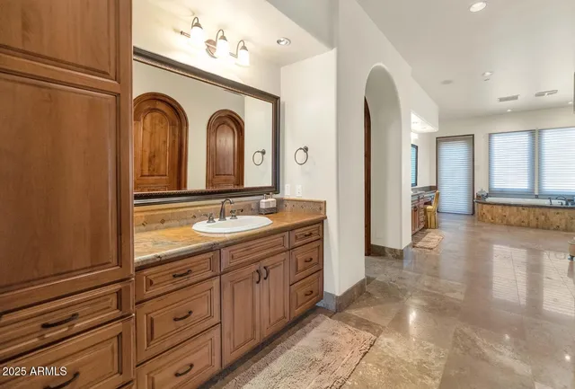 a spacious bathroom with a granite countertop sink a mirror and a shower