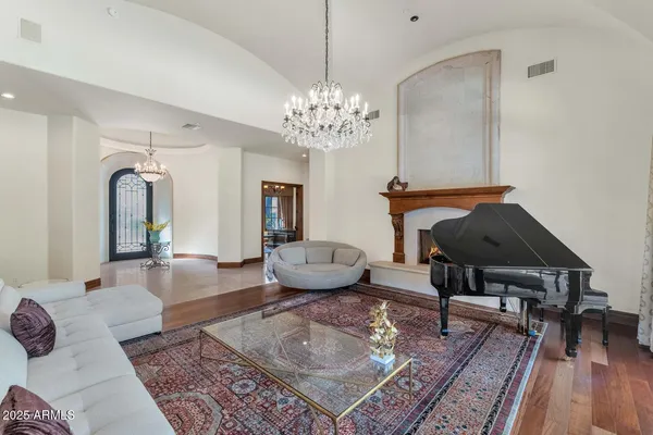 a living room with furniture a chandelier and a rug