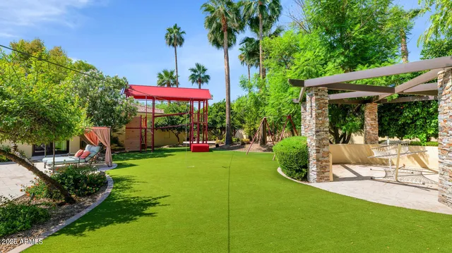 a view of a patio with table and chairs potted plants and large tree