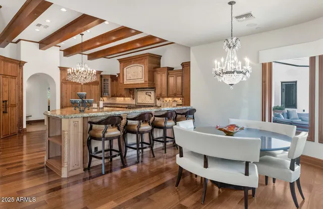a dining room with furniture a chandelier and wooden floor