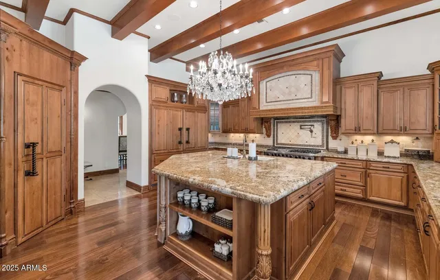 a kitchen with stainless steel appliances granite countertop a kitchen island a stove a sink dishwasher and cabinets with wooden floor