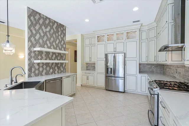 a kitchen with stainless steel appliances granite countertop a refrigerator and cabinets