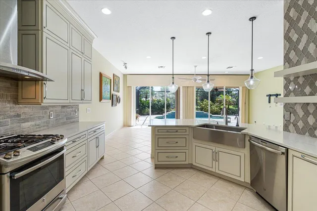 a kitchen with stainless steel appliances granite countertop a sink a refrigerator and a wooden floor