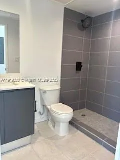 a bathroom with a toilet a sink a shower and a mirror