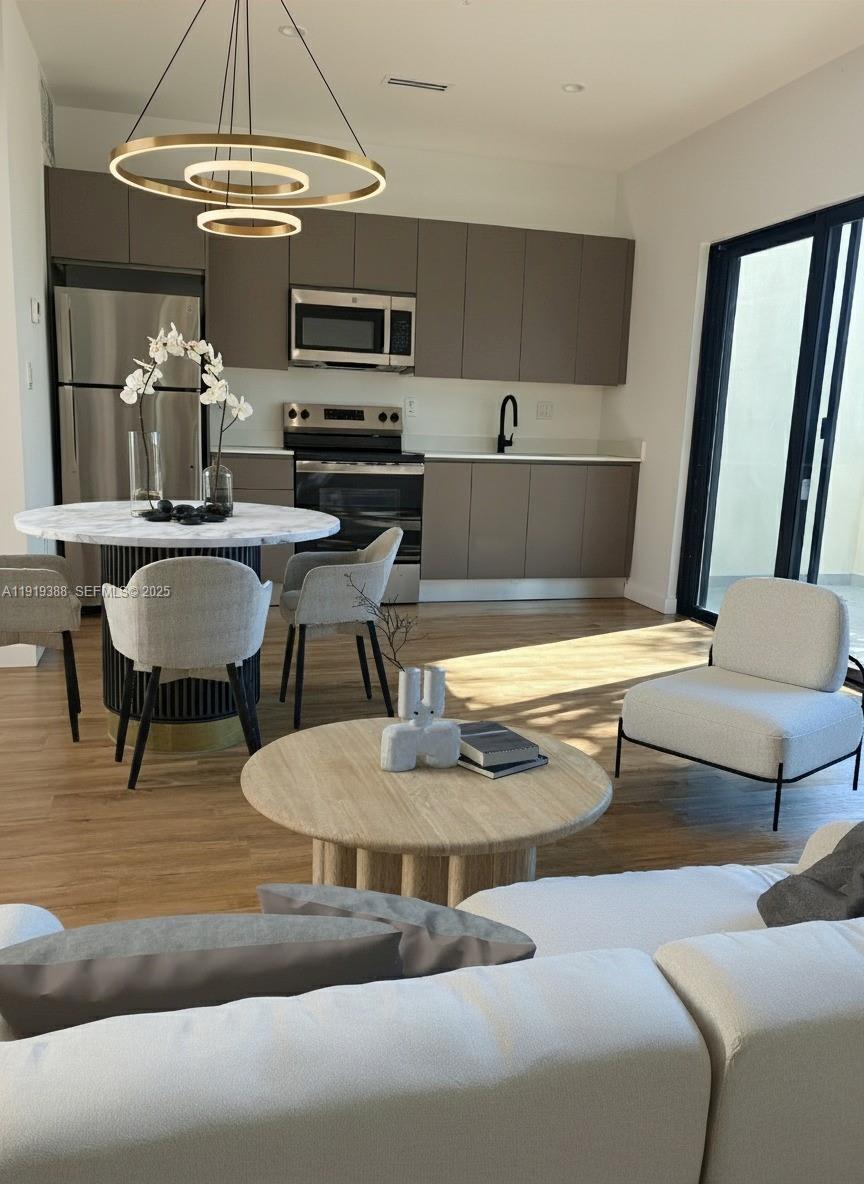 85 Northeast 55th Street, Unit 4 Miami, FL 33137 - Photo 6 of 15 a living room with furniture and a chandelier