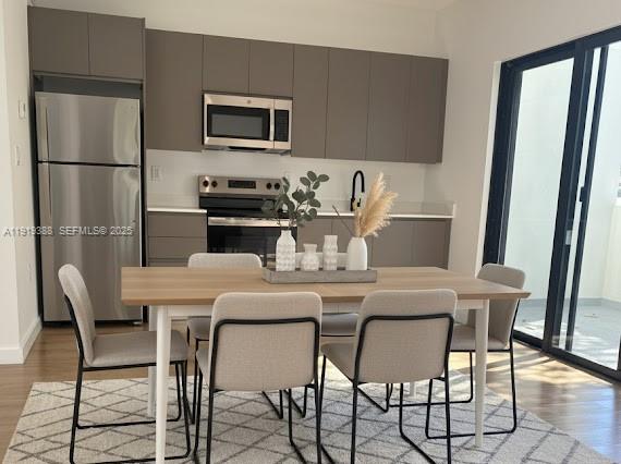 85 Northeast 55th Street, Unit 4 Miami, FL 33137 - Photo 8 of 15 a kitchen with a table chairs refrigerator and microwave