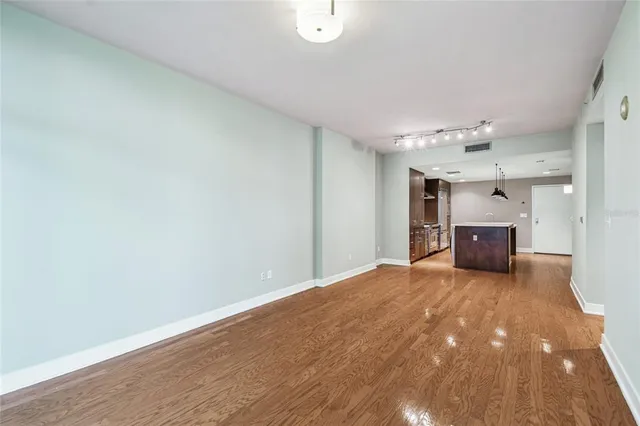 a view of empty room with wooden floor