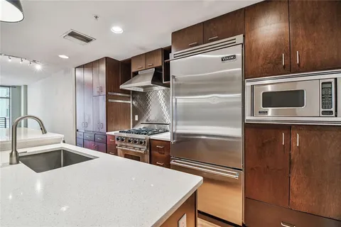 a kitchen with a sink a island and wooden floor