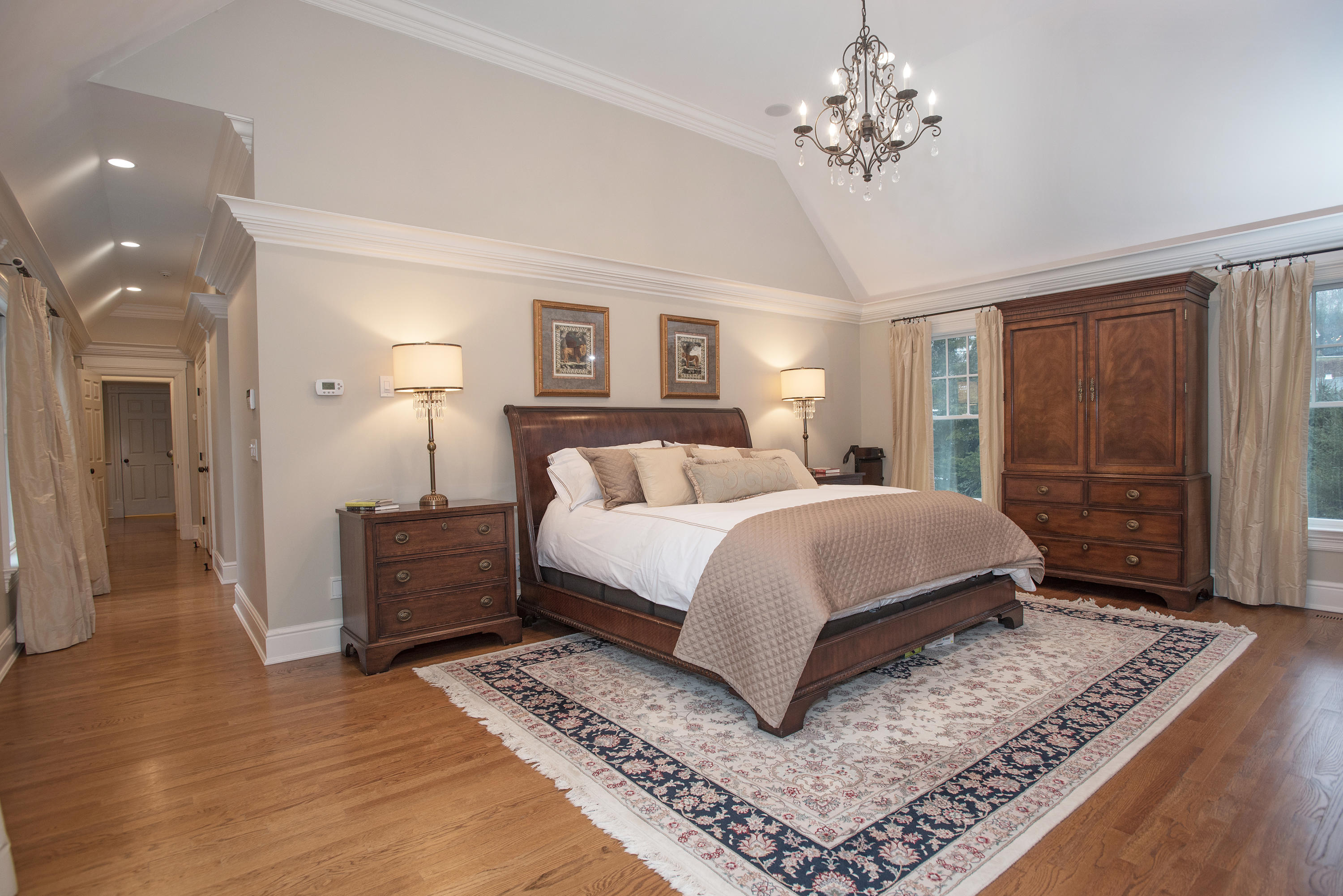 130 Skyview Lane New Canaan, CT 06840 - Photo 23 of 44 a spacious bedroom with a large bed and a chandelier