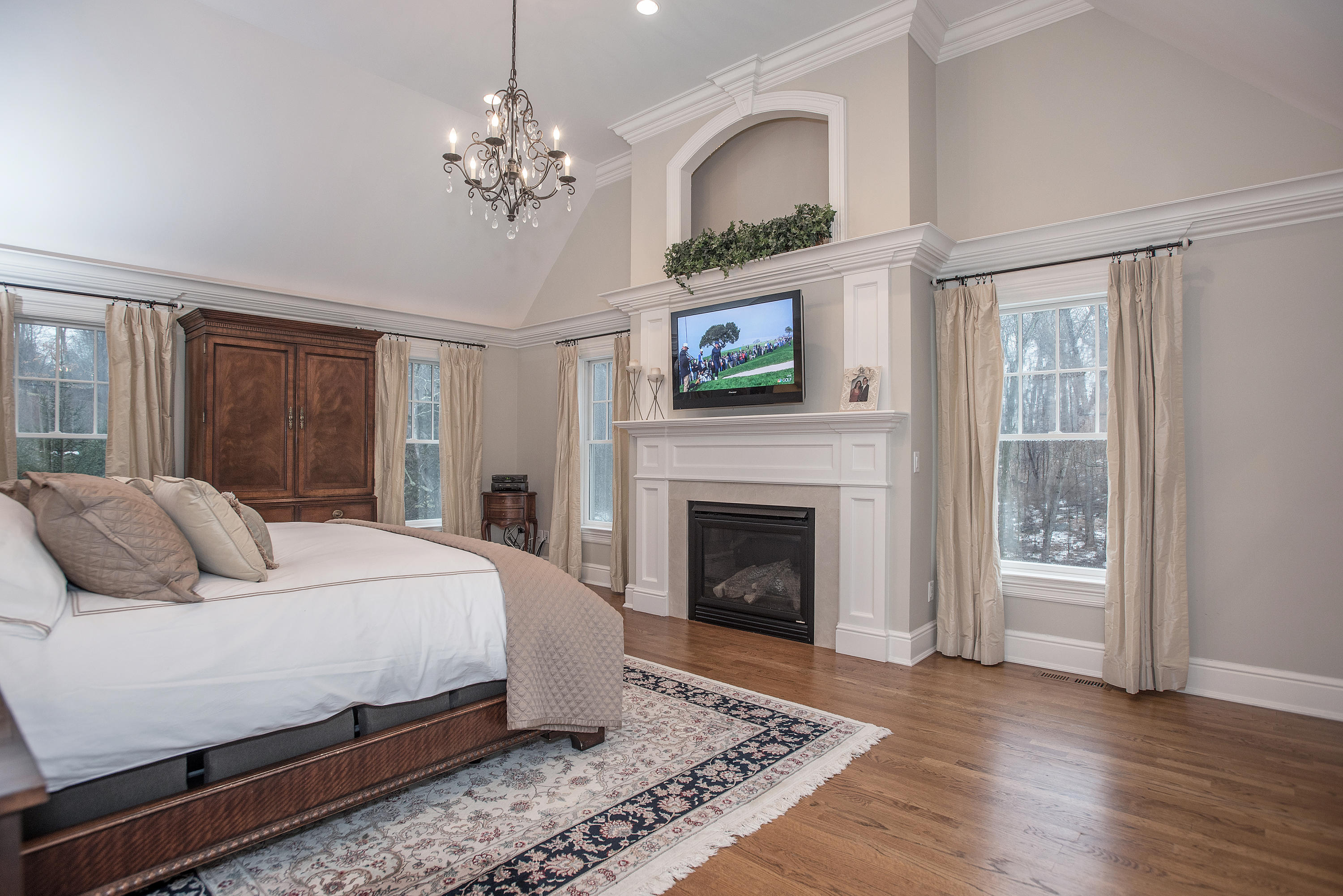 130 Skyview Lane New Canaan, CT 06840 - Photo 26 of 44 a spacious bedroom with a balcony a bed and a fireplace