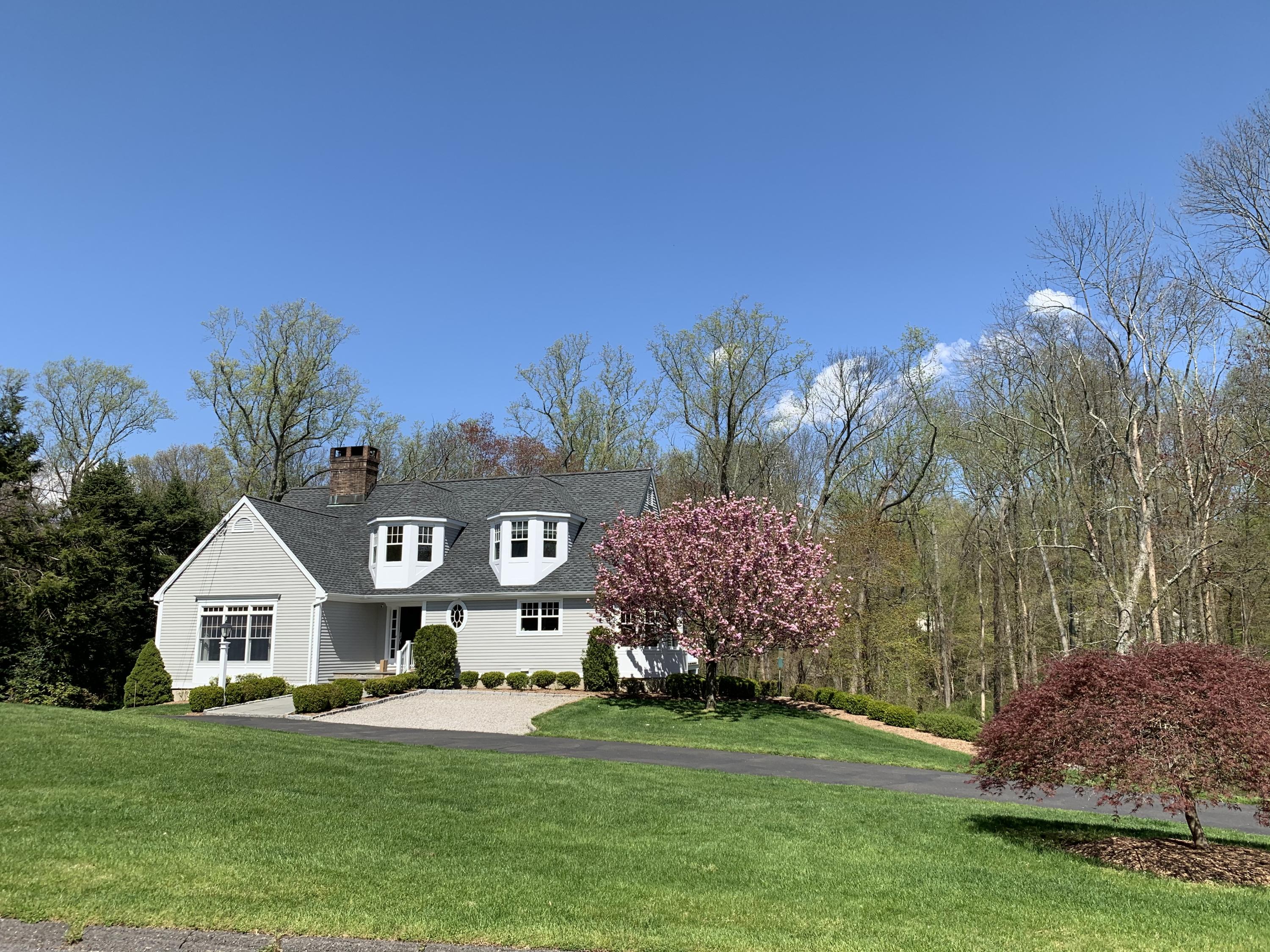 130 Skyview Lane New Canaan, CT 06840 - Photo 3 of 44 a front view of a house with a garden and trees