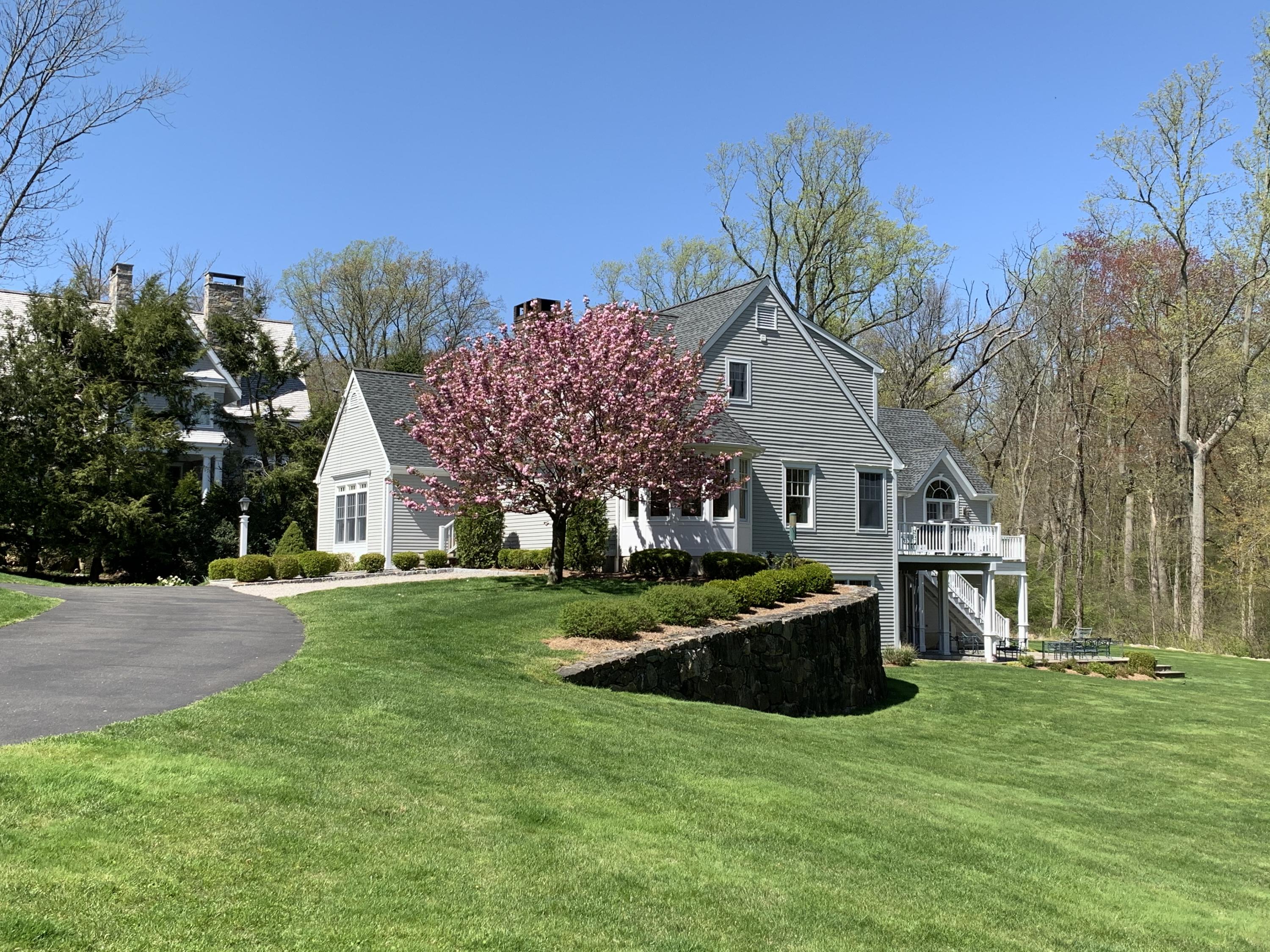 130 Skyview Lane New Canaan, CT 06840 - Photo 43 of 44 a front view of house with yard and trees in the background