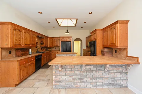 a kitchen with stainless steel appliances granite countertop a stove top oven a sink dishwasher and cabinets with wooden floor