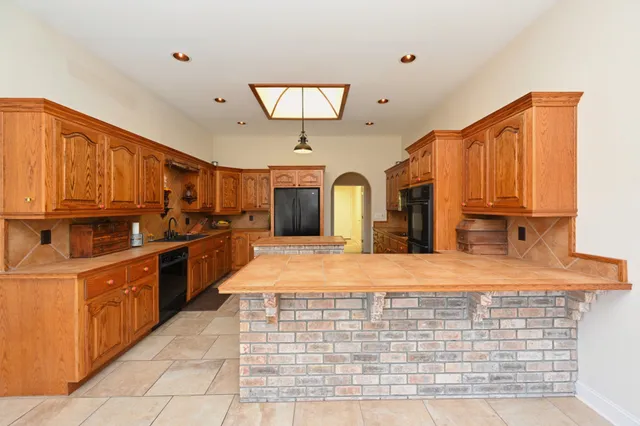 a kitchen with stainless steel appliances granite countertop a stove top oven a sink dishwasher and cabinets with wooden floor