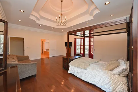 a bedroom with a large bed and a chandelier