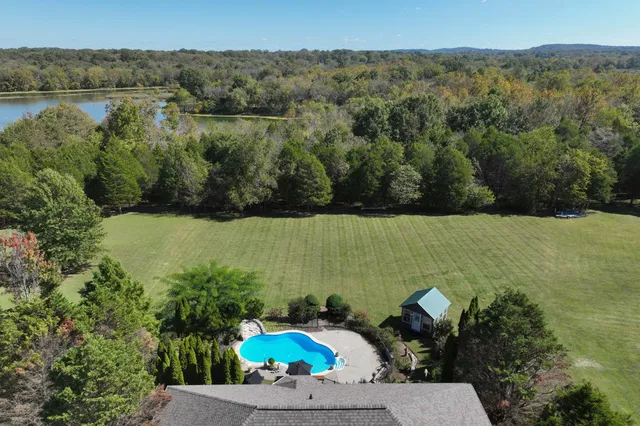 a view of a lake with a yard and mountain in the back