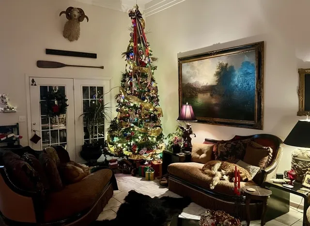 a living room with furniture flowers and a flat screen tv