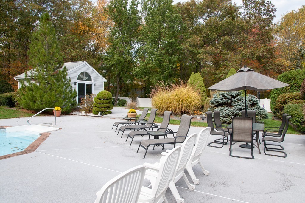 42 Magnolia Road Sharon, MA 02067 - Photo 23 of 24 a view of a patio with furniture and a table and chairs under an umbrella