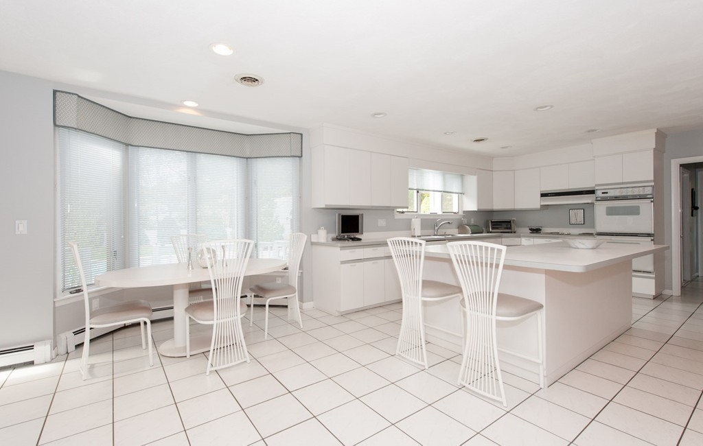 42 Magnolia Road Sharon, MA 02067 - Photo 5 of 24 a kitchen with a dining table chairs and white appliances