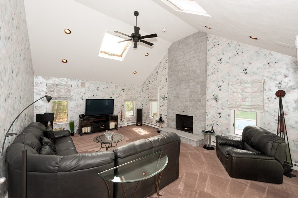 42 Magnolia Road Sharon, MA 02067 - Photo 8 of 24 a living room with furniture a fireplace and a flat screen tv