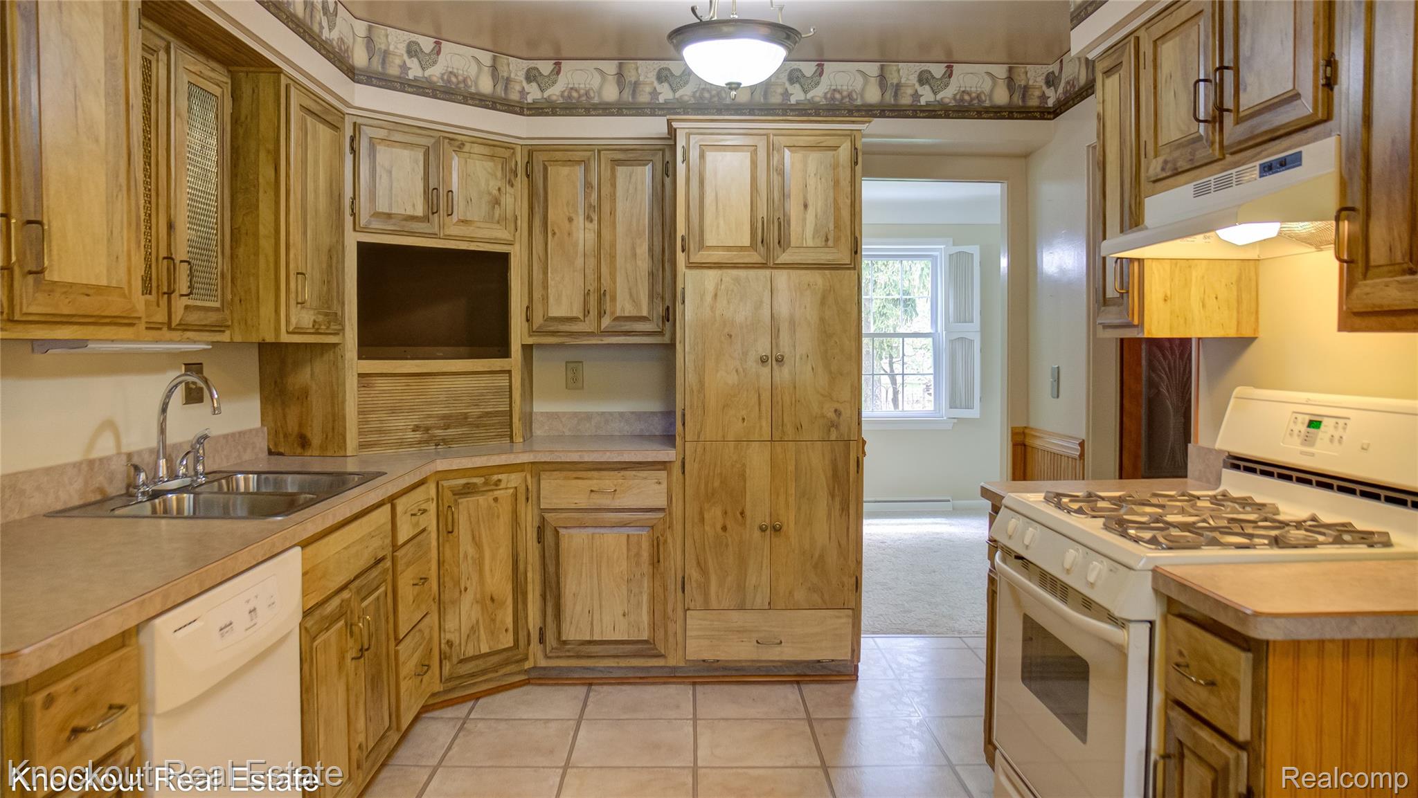 4465 Dirker Road Saginaw, MI 48638 - Photo 18 of 56 Kitchen featuring white appliances, light countertops, light tile patterned floors, and wood finish cabinets