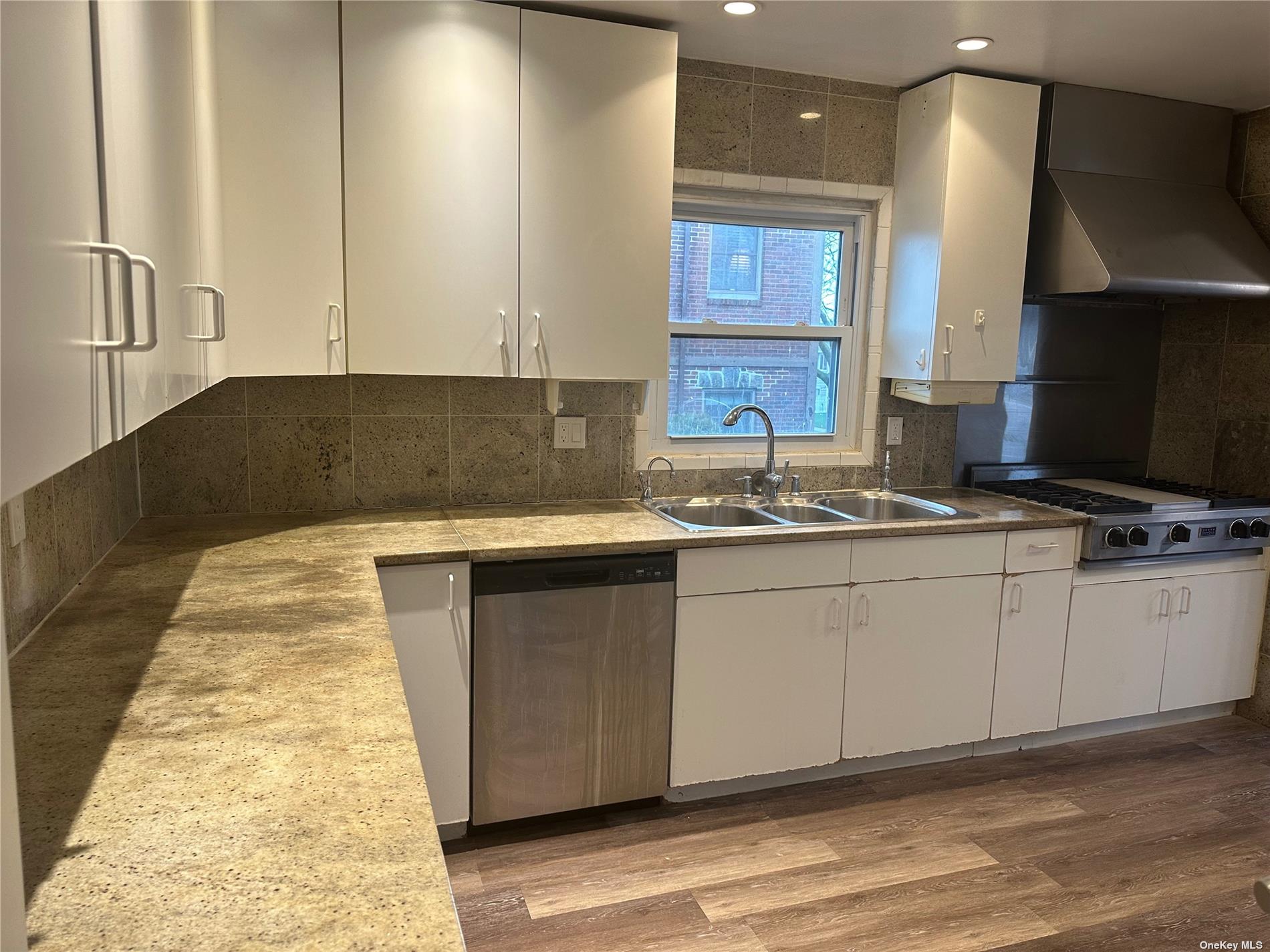 a kitchen with granite countertop a sink and a stove