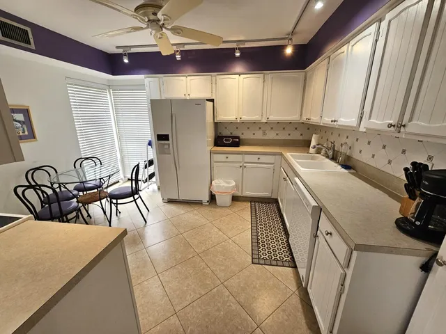 a kitchen with a sink a refrigerator and cabinets