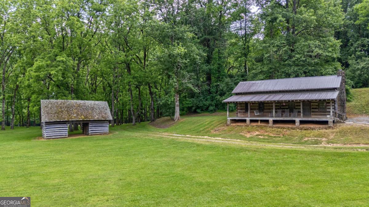 7320 Chestnut Valley Road Hiawassee, GA 30546 - Photo 24 of 91 a view of a house with a big yard and large trees