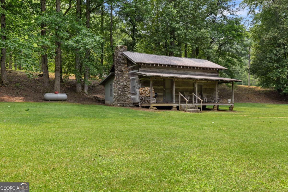 7320 Chestnut Valley Road Hiawassee, GA 30546 - Photo 28 of 91 a view of a patio with table and chairs under an umbrella