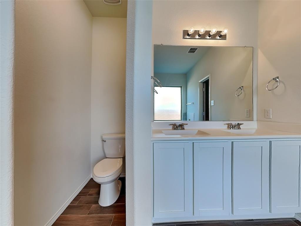 506 Robinson Way Fate, TX 75189 - Photo 11 of 30 Full bathroom with double vanity and wood finish floors